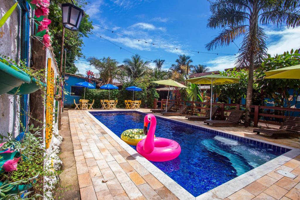 uma piscina com um cisne cor-de-rosa no meio em Pousada Villa Blu Maresias em Maresias