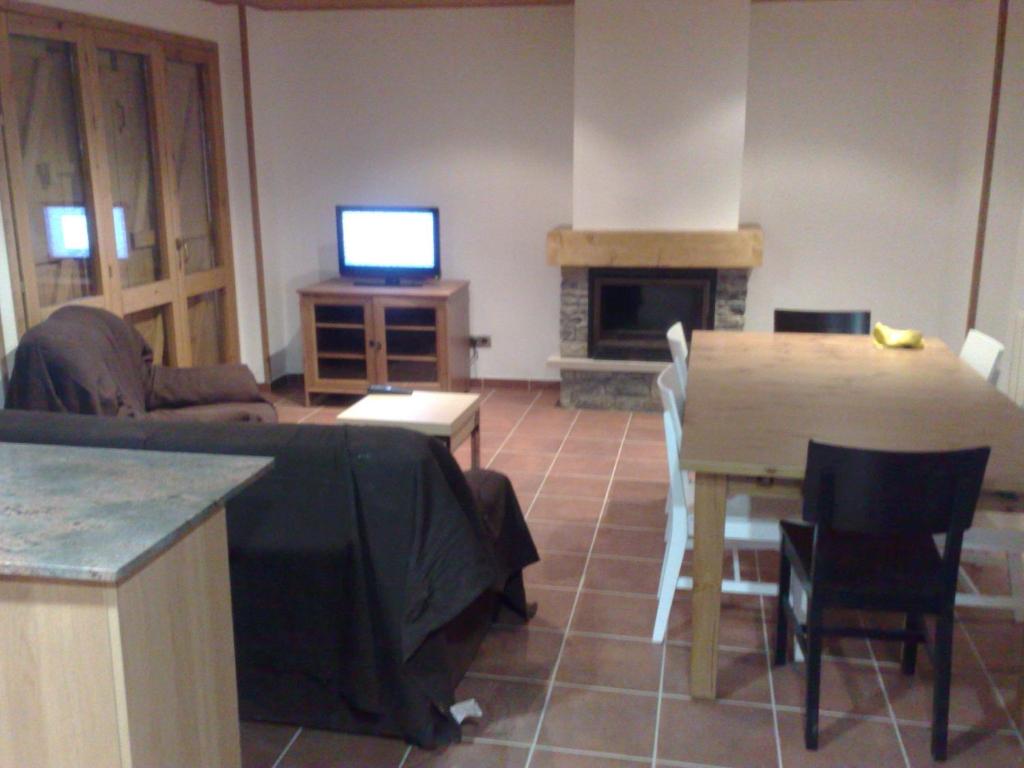 a living room with a table and a television and a table and chairs at Apartment in Llavorsi in the heart of the Catalan Pyrenees in Llavorsí