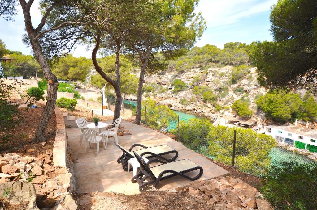 a patio with a table and chairs next to a river at Houm Villa Cala Pi in Cala Pi
