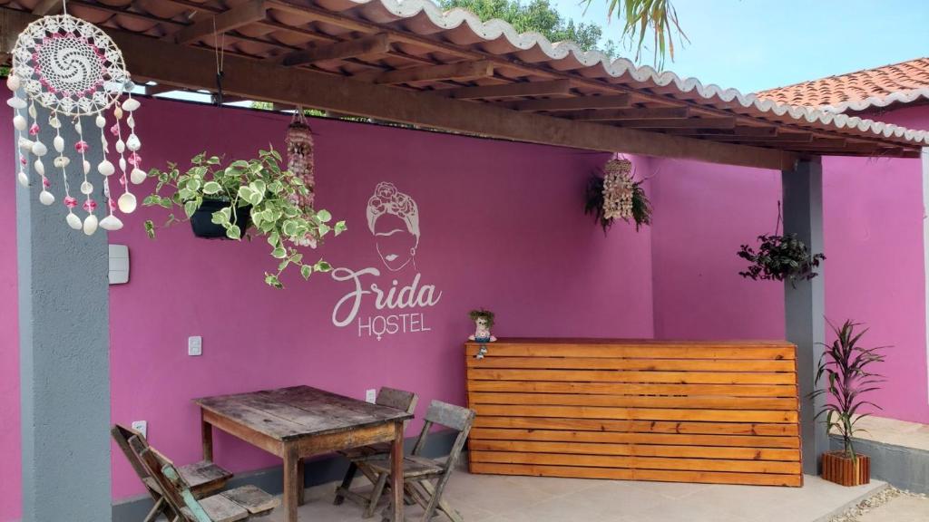 una parete viola con un tavolo davanti di Frida Hostel a Jericoacoara