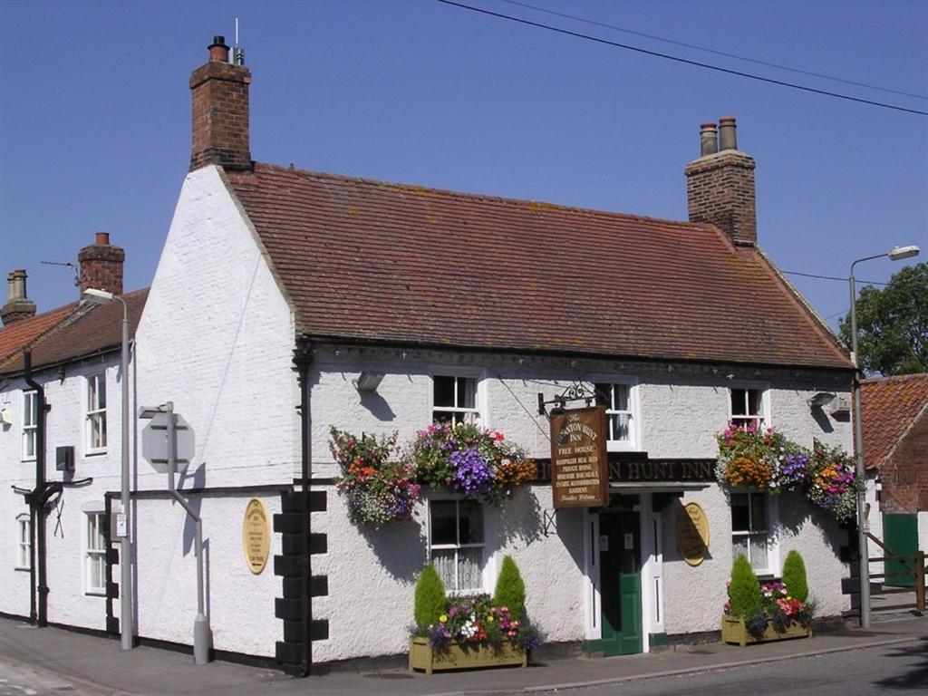 a white building with flowers in the window at Thornton Hunt Inn in Thornton Curtis