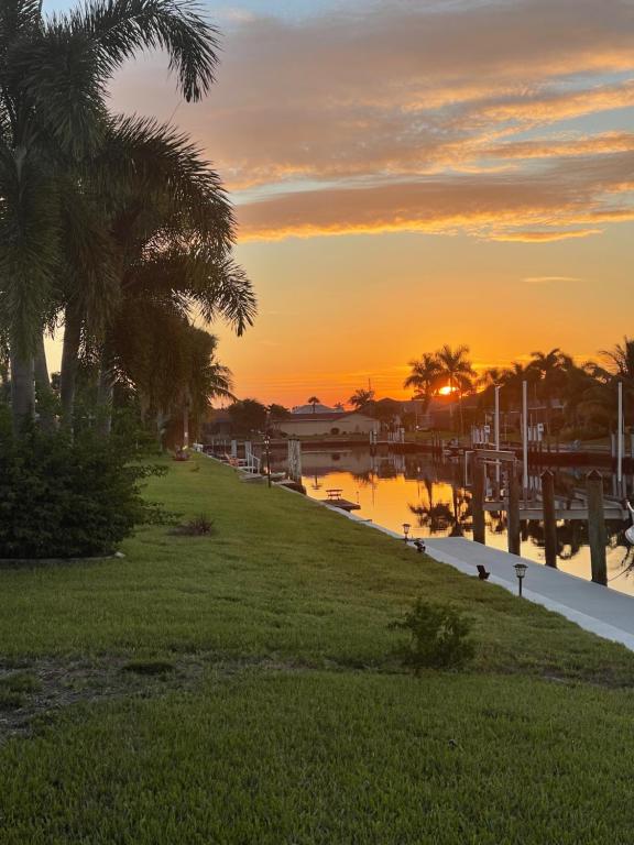 un coucher de soleil sur une étendue d'eau bordée de palmiers dans l'établissement Punta Gorda Isles Haven, à Punta Gorda