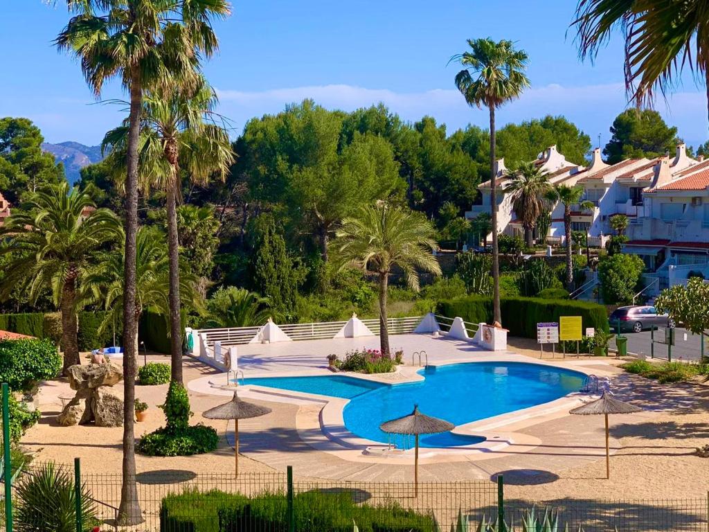 einen Pool mit Palmen und Sonnenschirmen in einem Resort in der Unterkunft Casa Julia with swimming pool in Cautivador