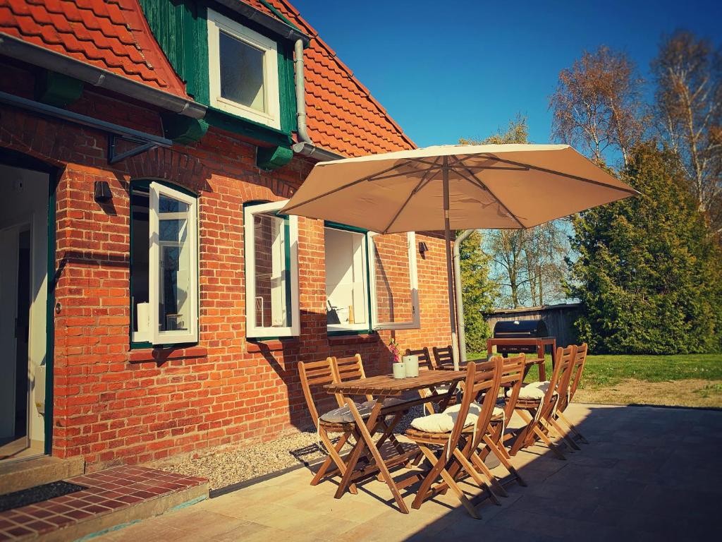 a wooden table and chairs with an umbrella at Gut Koselau Landhaus III 