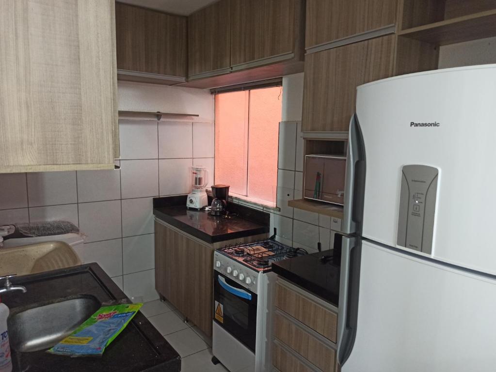 a kitchen with a refrigerator and a sink at Apto dois quartos, cozinha equipada, portaria 24 h, área de lazer in Imperatriz
