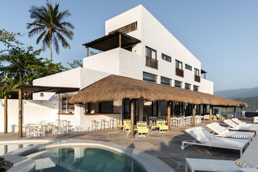 a building with chairs and tables and a swimming pool at Miradouro de São Sebastião in São Sebastião