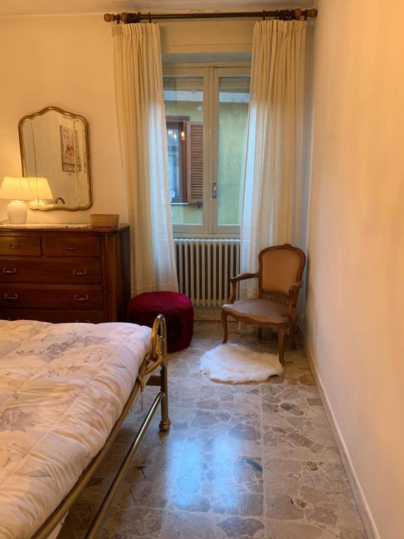 um quarto com uma cama, uma cadeira e um espelho em Casa Beltè em Ormea