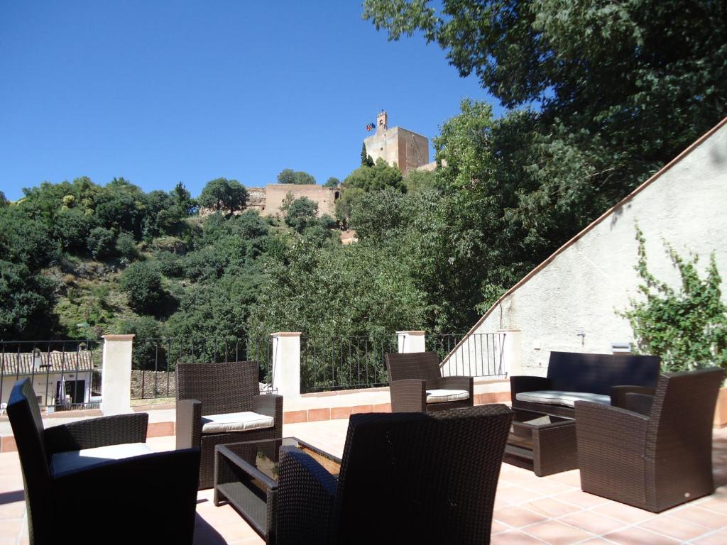 un grupo de sillas y mesas en un patio en Apartamentos Turísticos Mauror, en Granada