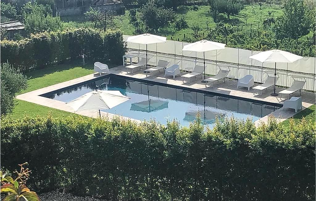 una vista sul tetto di una piscina con ombrelloni di 4 Bedroom Awesome Home In Viagrande a Viagrande