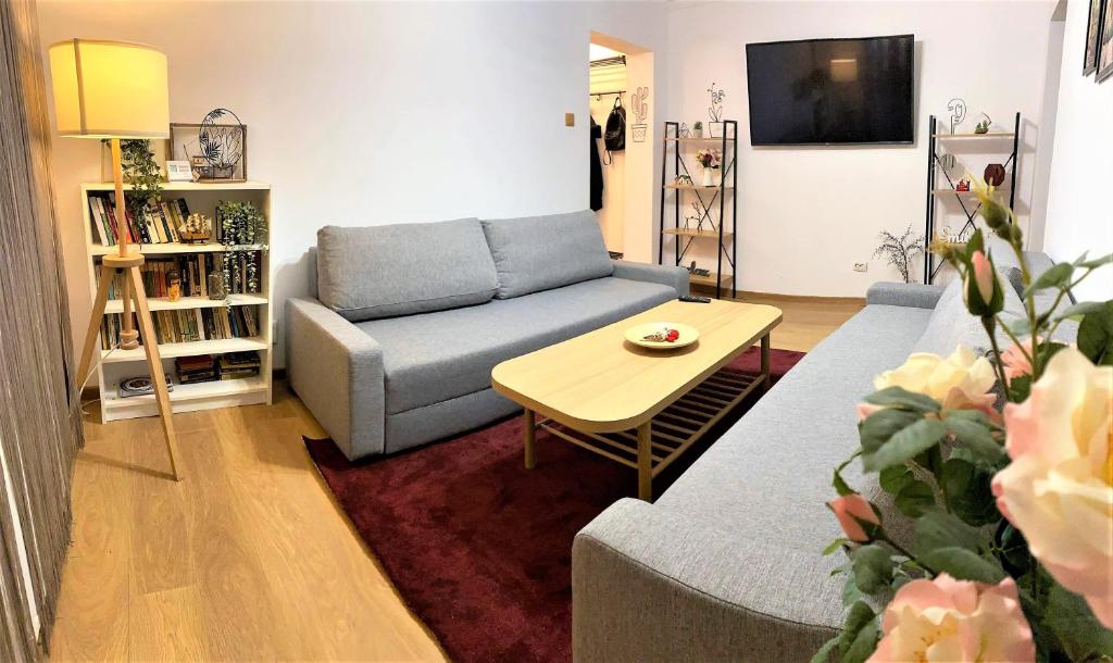 a living room with a couch and a table at Cosy Apart Busteni in Buşteni