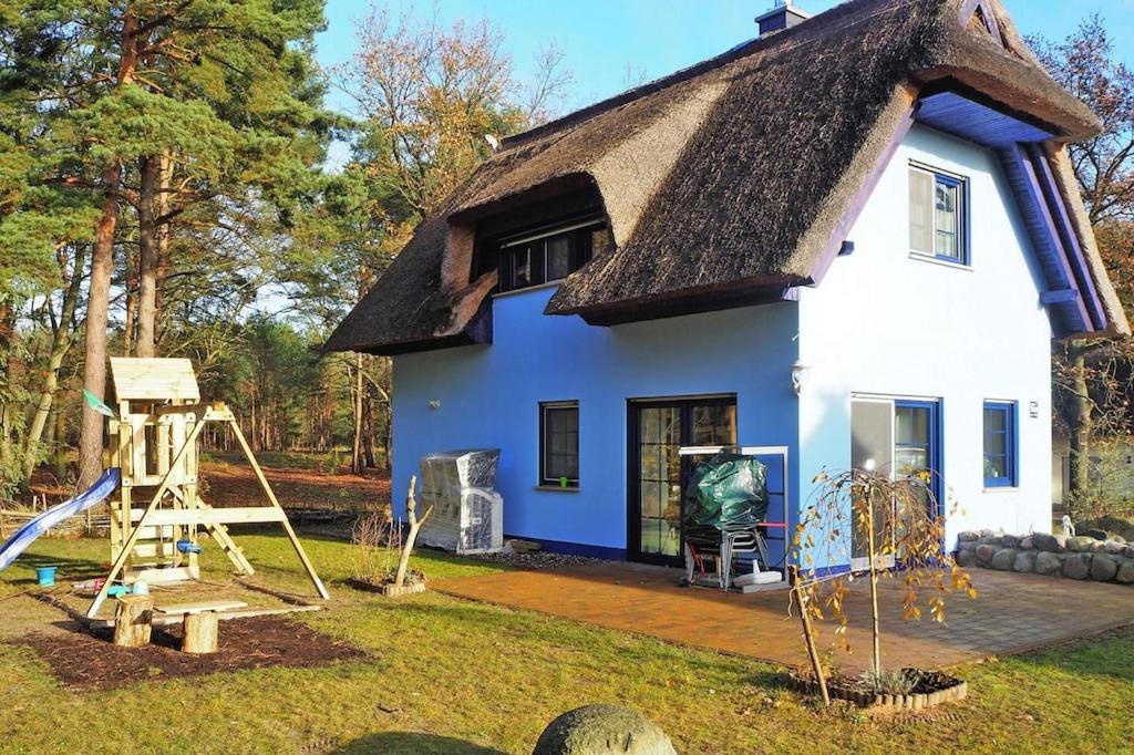 Casa azul y blanca con techo de paja en Holiday home my anchorage, Zirchow, en Zirchow