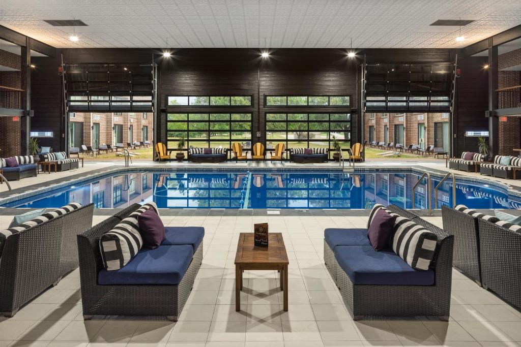 a large pool with chairs and a table in front of it at The Highlander Hotel in Iowa City