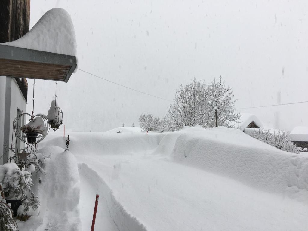 ein schneebedeckter Hof neben einem Haus in der Unterkunft Hüsmatta (Michael Gschwendtner) in Fieschertal