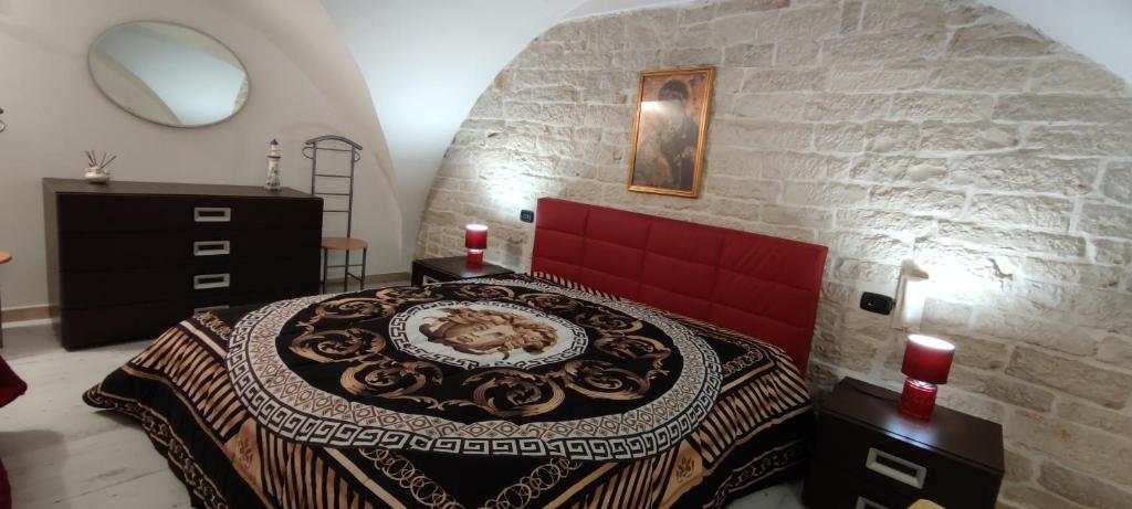 ein Schlafzimmer mit einem Bett in einer Steinmauer in der Unterkunft La Vela in Giovinazzo