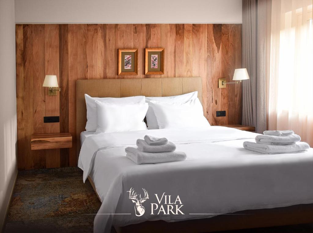ein Schlafzimmer mit einem Bett mit Handtüchern darauf in der Unterkunft Vila Park Bujtina in Prizren