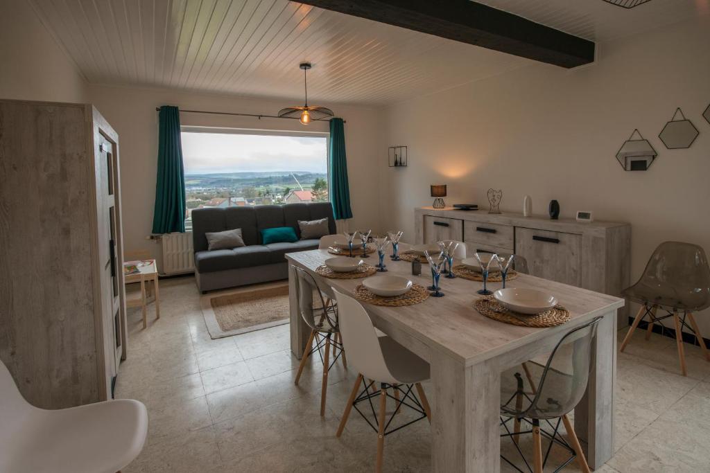 uma cozinha e sala de estar com mesa e cadeiras em Agimon'TOIT em Hastière-par-delà
