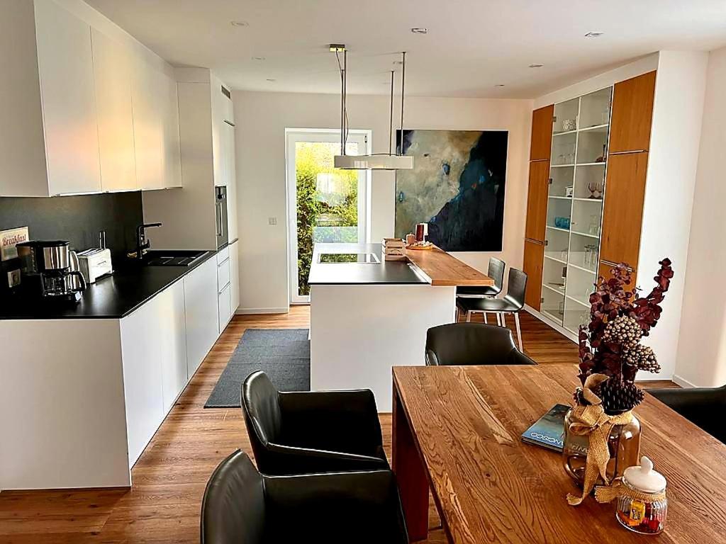 cocina y sala de estar con mesa de madera en Apartments bei Playmobil EG,130m2,große Terassen,24h Self Check-in, free Parking en Zirndorf