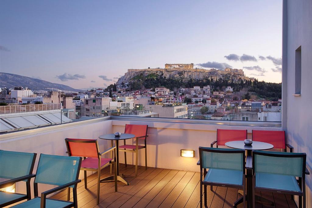 een balkon met tafels en stoelen en uitzicht op kippen bij Athens21 in Athene