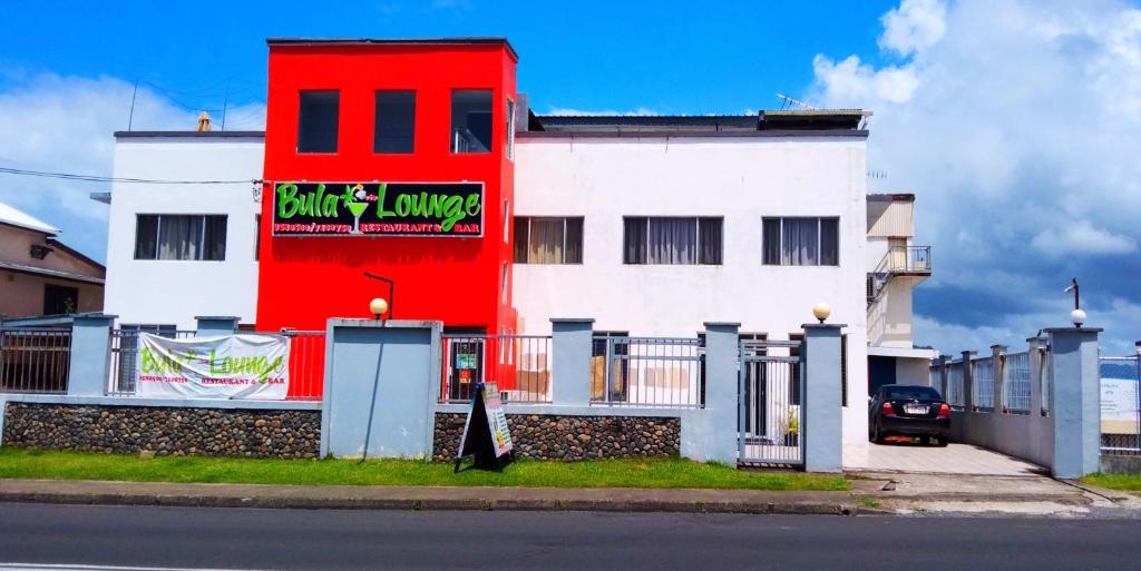 un bâtiment rouge et blanc avec un panneau sur celui-ci dans l'établissement Sunseekers Outrigger Hotel, à Suva