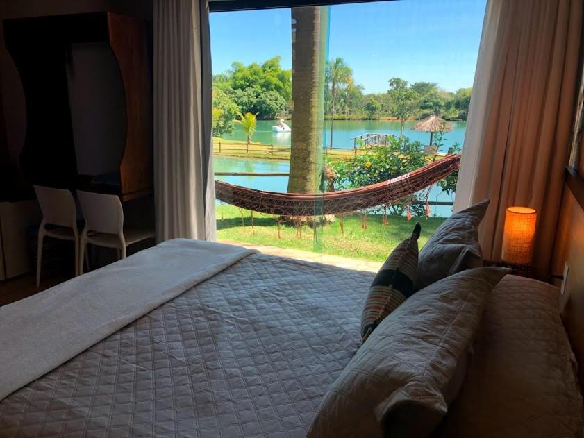 Villa Triacca Hotel Vinícola & Spa في برازيليا: غرفة نوم مع سرير ونافذة مع أرجوحة