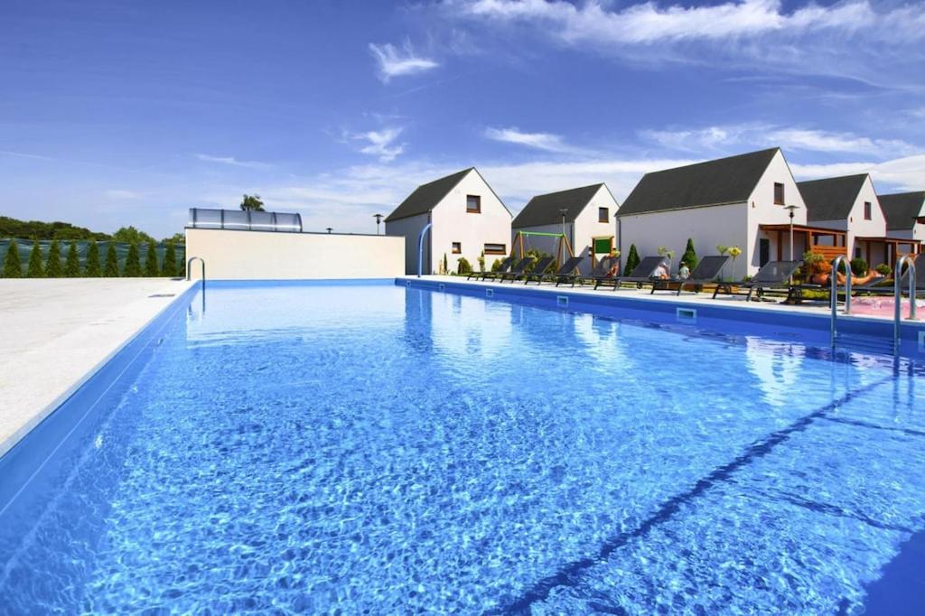 a large swimming pool with blue water in front of houses at Holiday resort, Rogowo in Rogowo