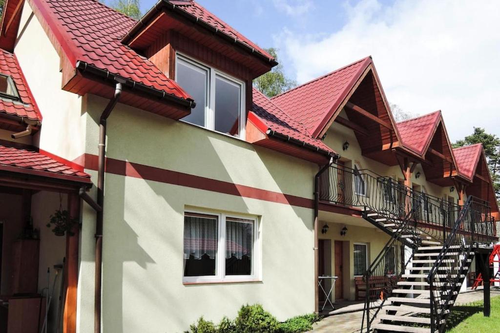 una casa con techo rojo y escalera en holiday home, Pobierowo, en Pobierowo