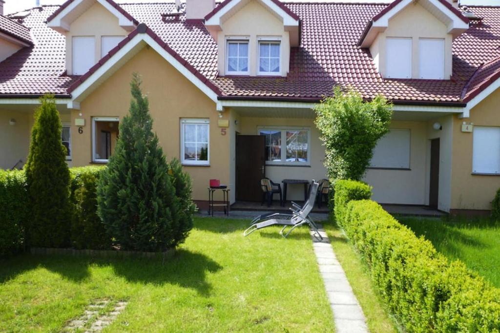 ein Haus mit einem Stuhl im Hof in der Unterkunft Terraced house, Rewal in Rewal