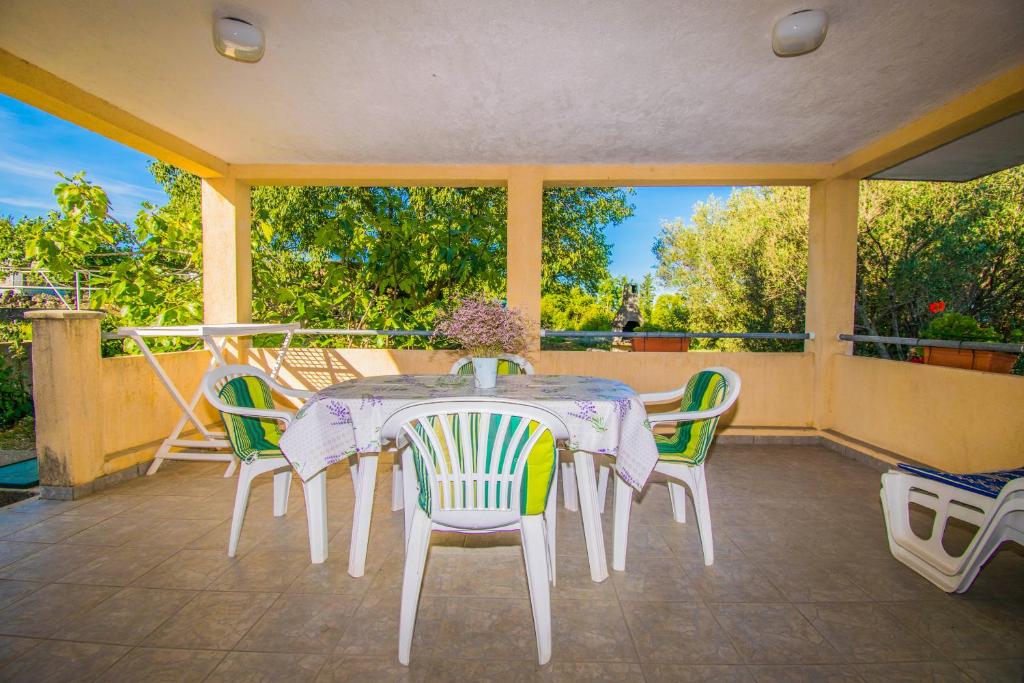 a table and chairs sitting on a porch at Apartment IN KLANICE Dobrinj, island Krk in Dobrinj
