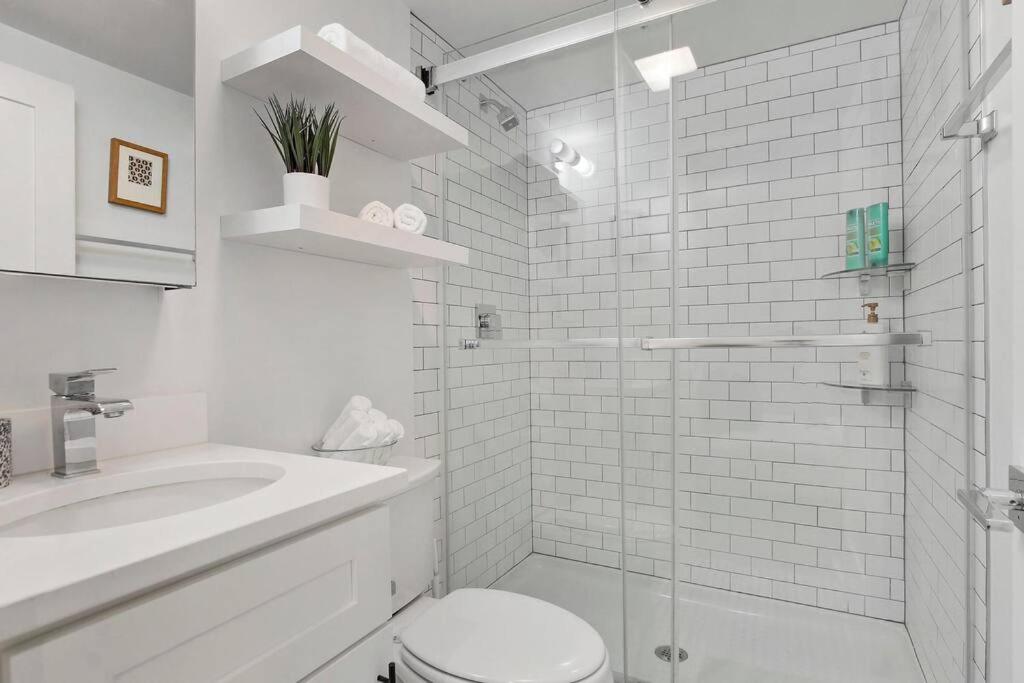 La salle de bains blanche est pourvue de toilettes et d'un lavabo. dans l'établissement Elite Uptown Studio Apt close to Shops - Montrose 313, à Chicago