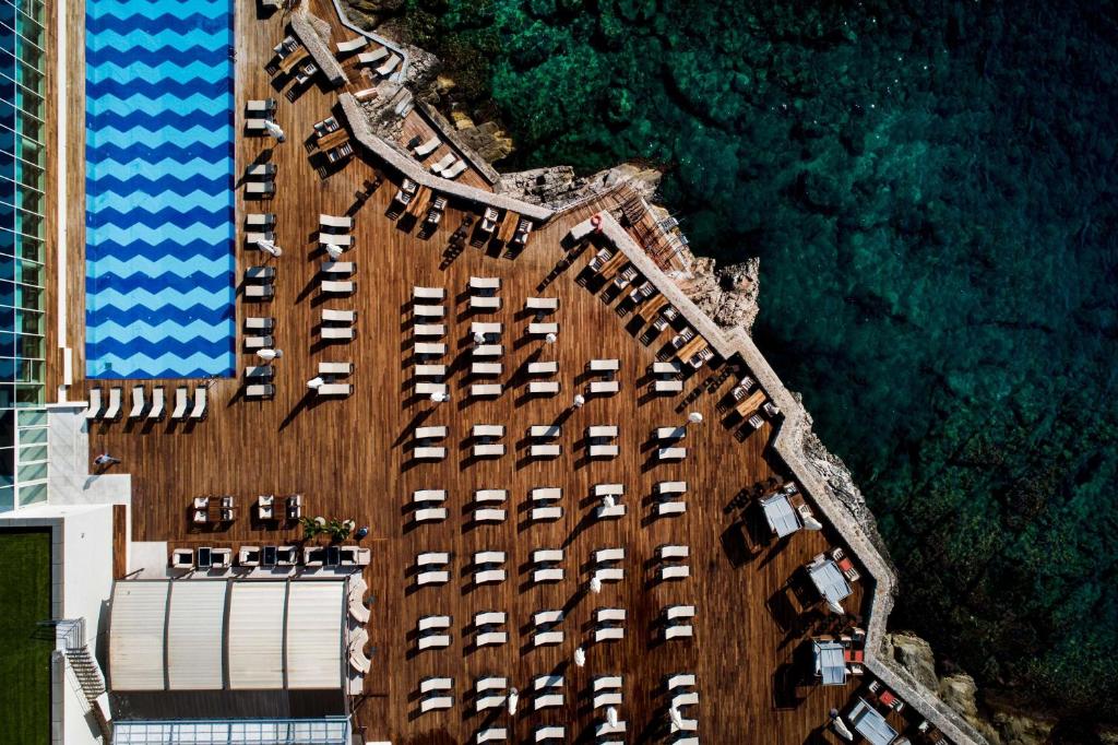 widok na budynek z samochodami nad oceanem w obiekcie Rixos Premium Dubrovnik w Dubrowniku