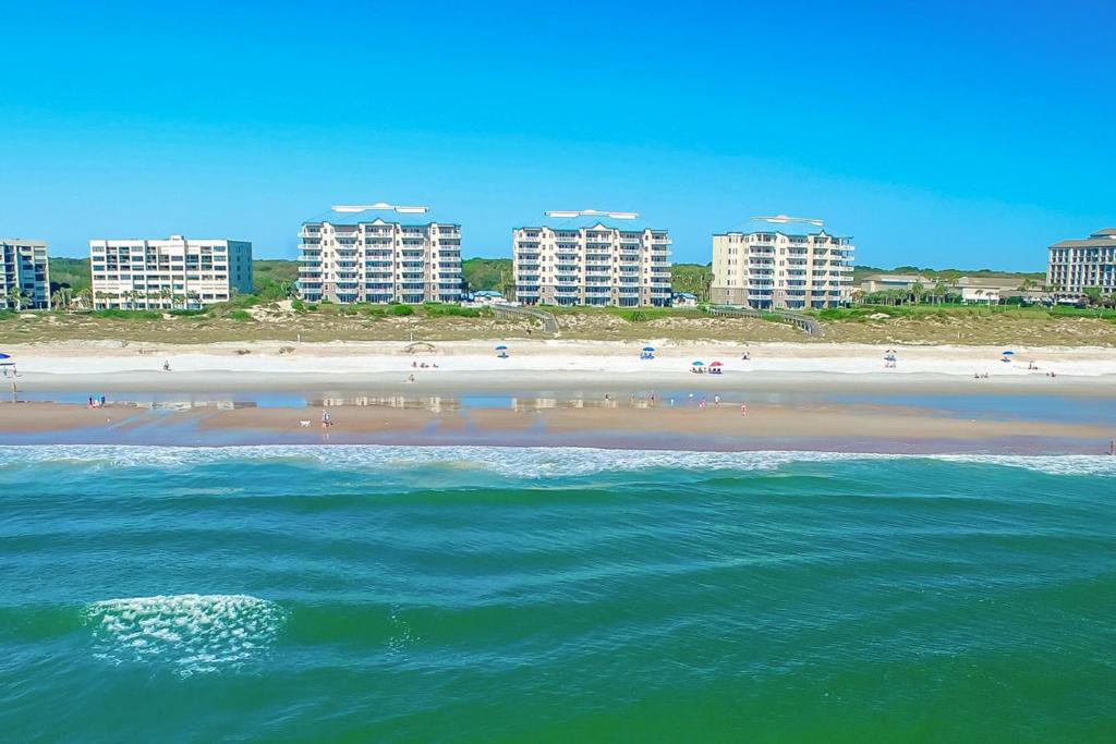 a beach with buildings in the background and the ocean at Ocean Place in Fernandina Beach