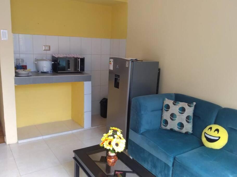 een woonkamer met een blauwe bank en een keuken bij Kely1 Primer Piso in Lima