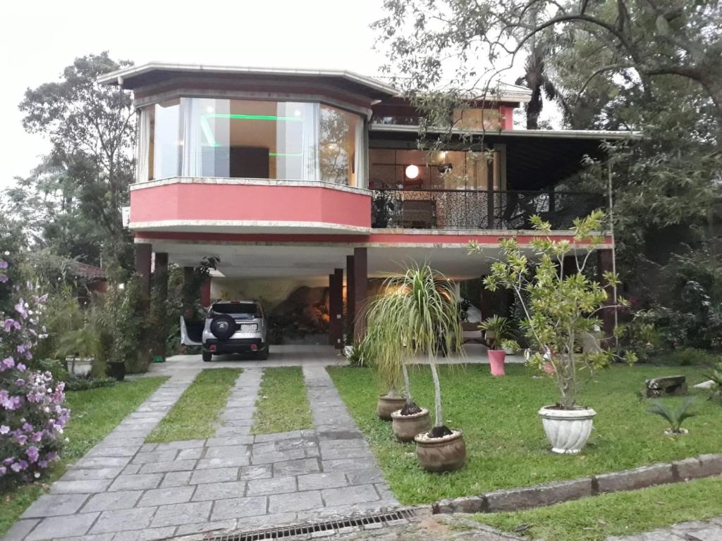 ein Haus mit einem davor geparkt in der Unterkunft Casa dos sonhos - Alto Padrão in Guapimirim