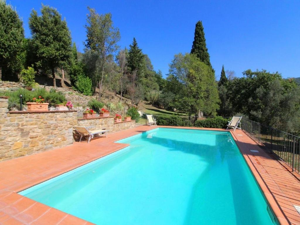 - une piscine dans une cour dotée d'un mur en pierre dans l'établissement Belvilla by OYO Borgo Caprile, à Castiglion Fiorentino
