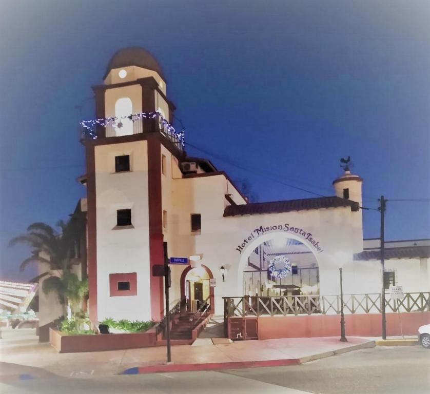 a building with a clock tower on a street at MISION SANTA ISABEL in Ensenada