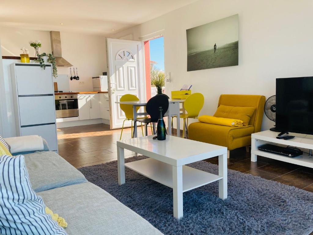 a living room with a couch and a table at Grand appartement 1ch vue Océan in Soulac-sur-Mer