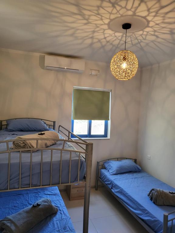 1 dormitorio con 2 literas y lámpara de araña en Ir-Rixa Holiday Penthouse, en Għajnsielem