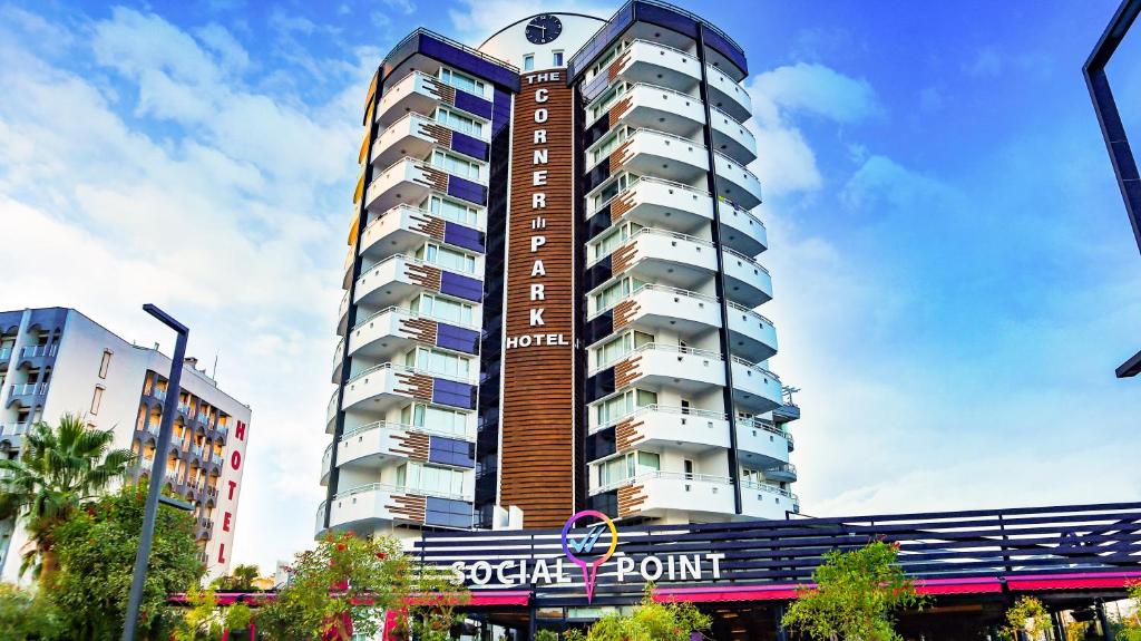 un grand bâtiment avec une horloge en haut dans l'établissement The Corner Park Hotel, à Antalya