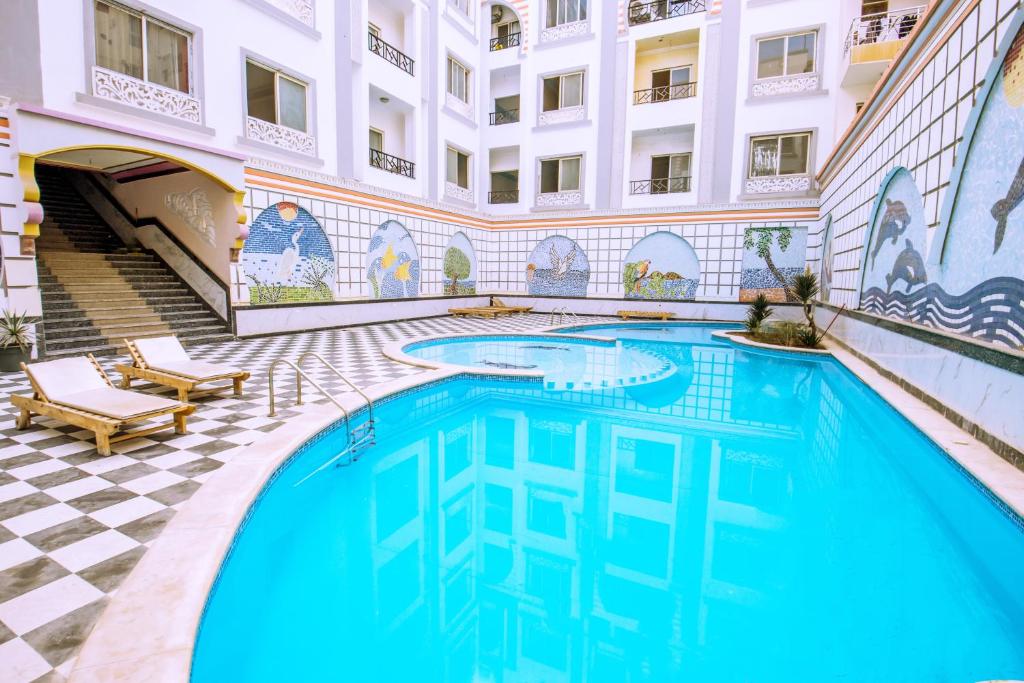 a pool in the courtyard of a building with blue water at Rare New Marina Hotspot With Pool & Fast Free WIFI - Western Standards - Sheraton Plaza 415 in Hurghada