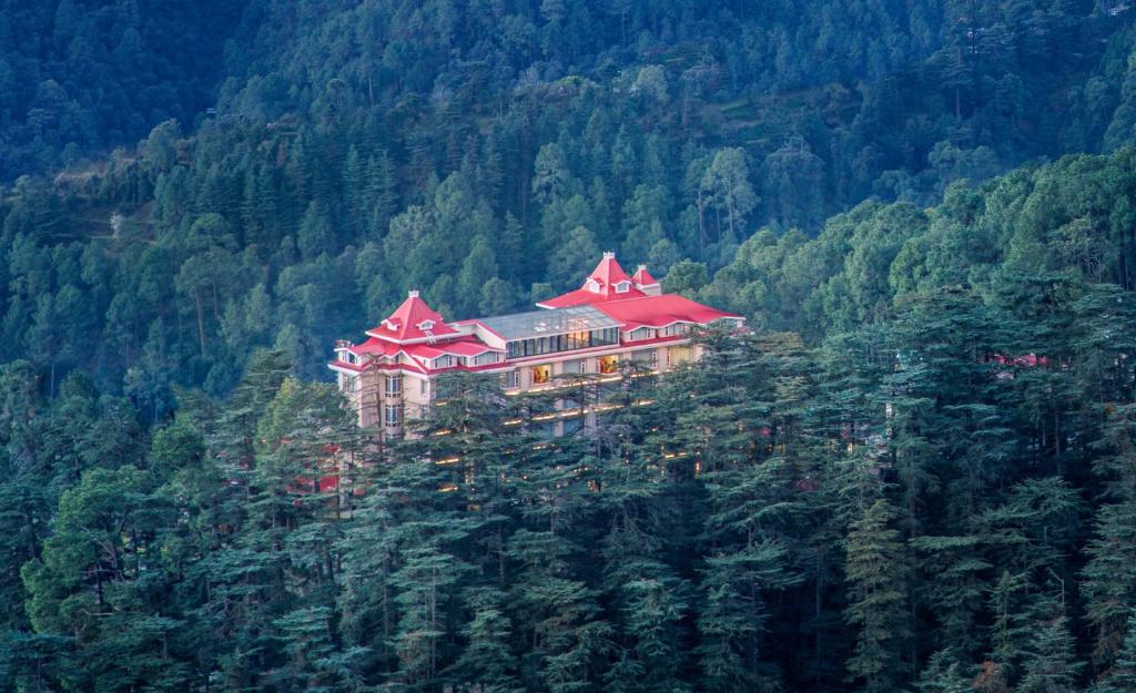 un grande edificio in cima a una montagna di WelcomHeritage Elysium Resort & Spa a Shimla