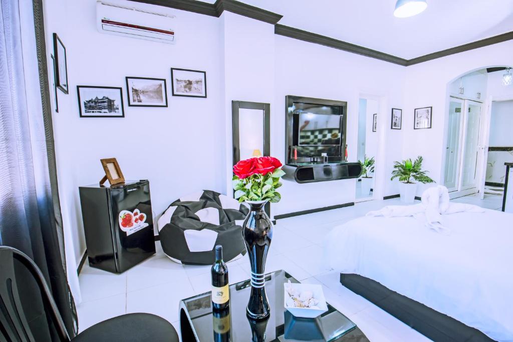 a living room with a table with a vase with a red rose at Rare 2BD Marina Hotspot With Pool, Fast Free WIFI & Balcony - 2 Kitchens & 2 Bathrooms - Western Standards - Sheraton Plaza 414-415 in Hurghada