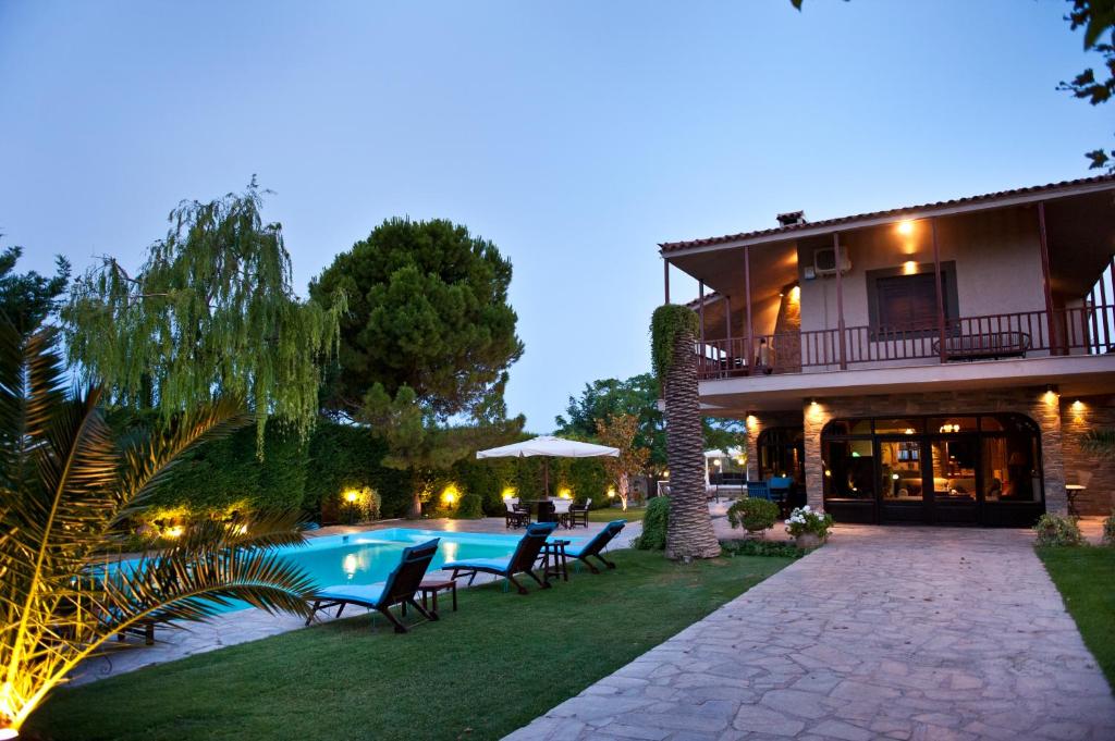Paralía Avlídhos的住宿－Villa Bona: A secluded villa less than 50 min. from Athens Intl. Airport，庭院中带游泳池的房子