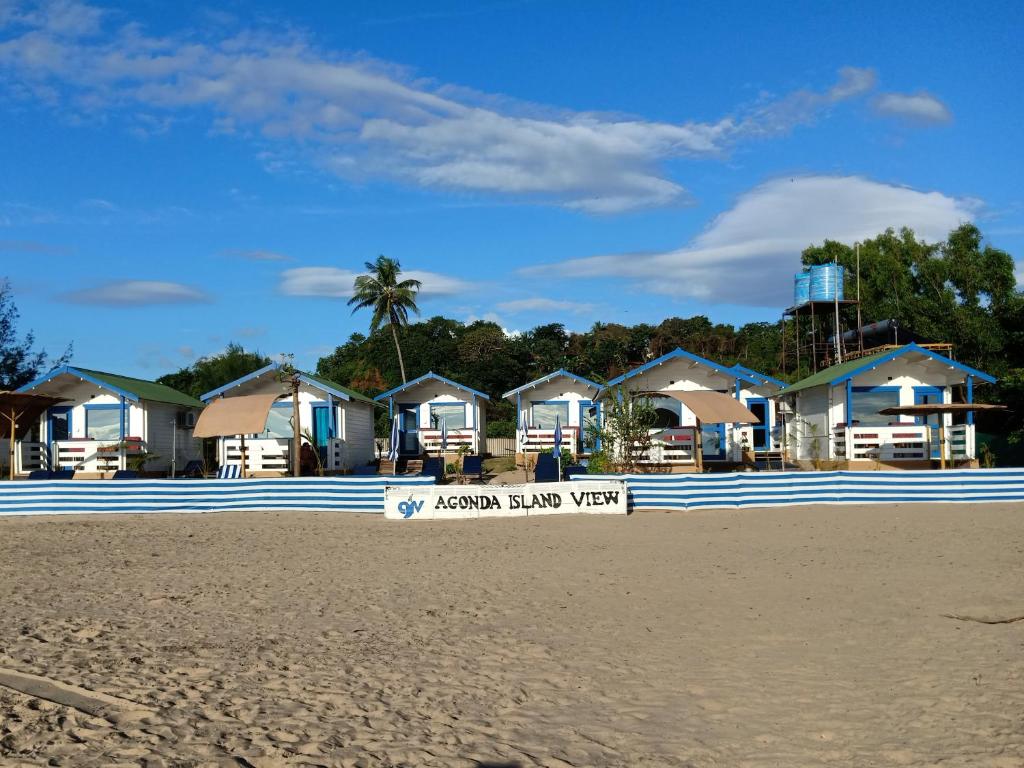 uma fila de casas numa praia com uma placa em Agonda island view em Agonda
