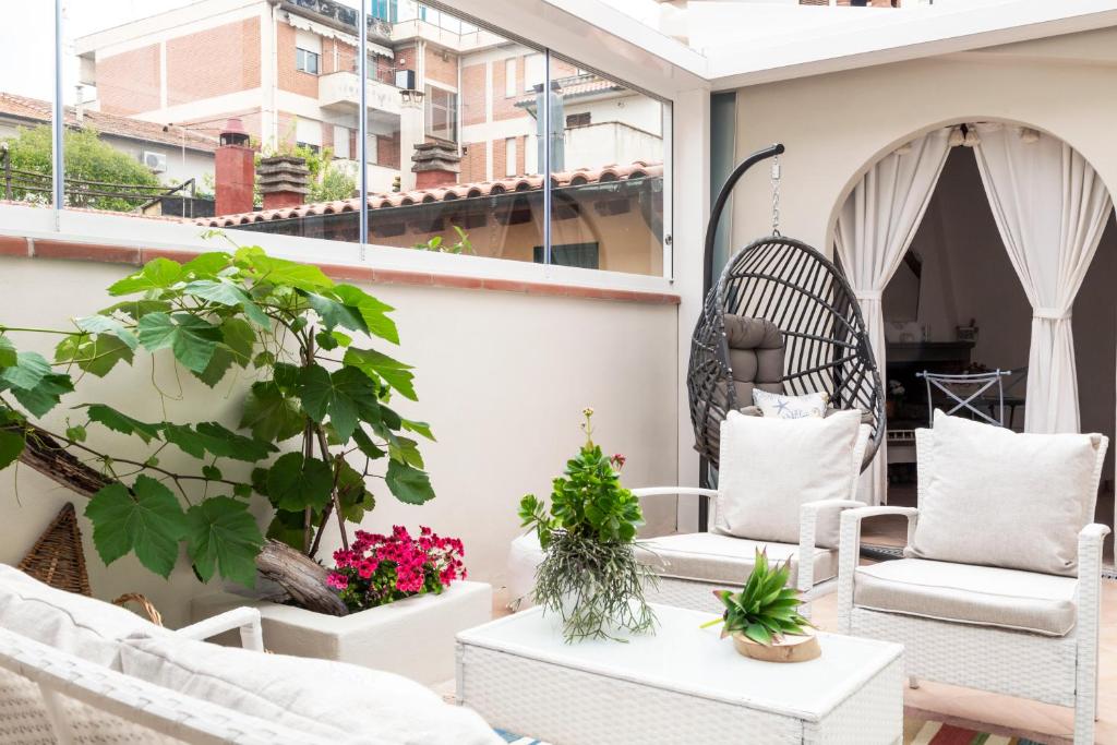 a balcony with white chairs and potted plants at Acquamarina b&b in Follonica