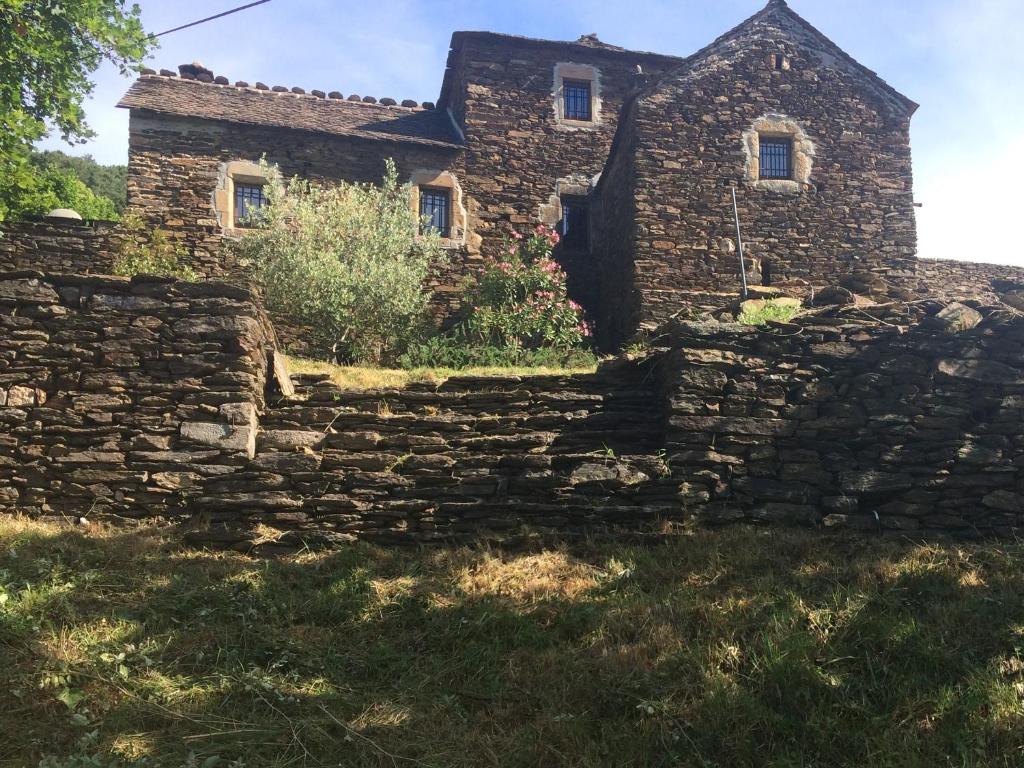 an old stone house behind a stone wall at MAISON DE CHARME EN ARDECHE DU SUD AVEC PISCINE in Beaumont