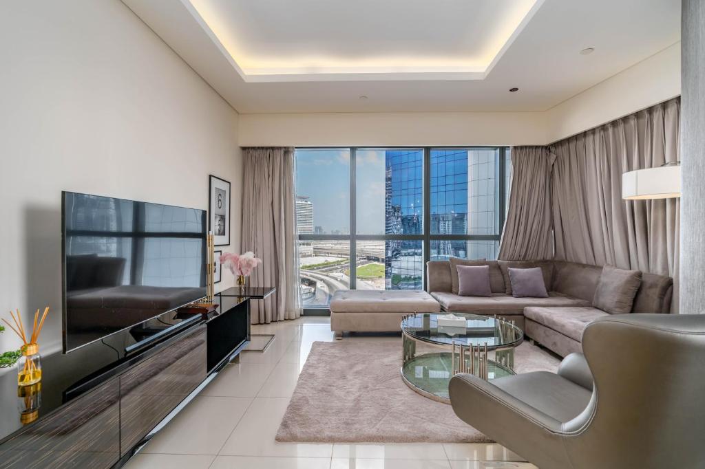 a living room with a couch and a tv at Splendid 2-Bedroom Apartment in Paramount Towers in Dubai