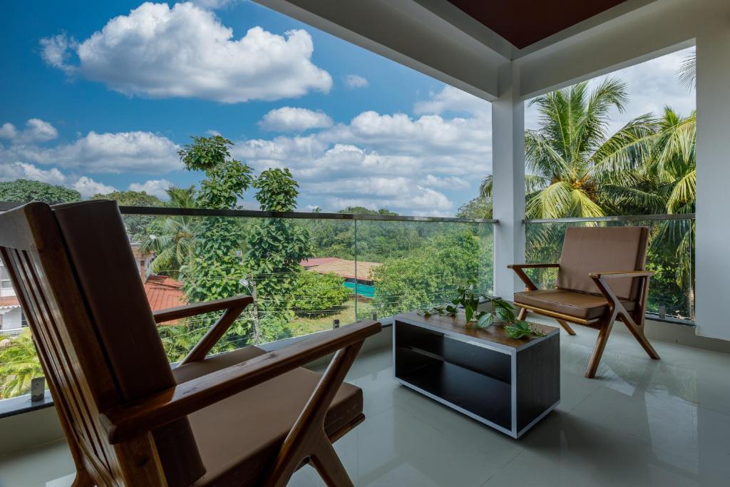 a living room with two chairs and a large window at Om Shanti Residence in Canacona