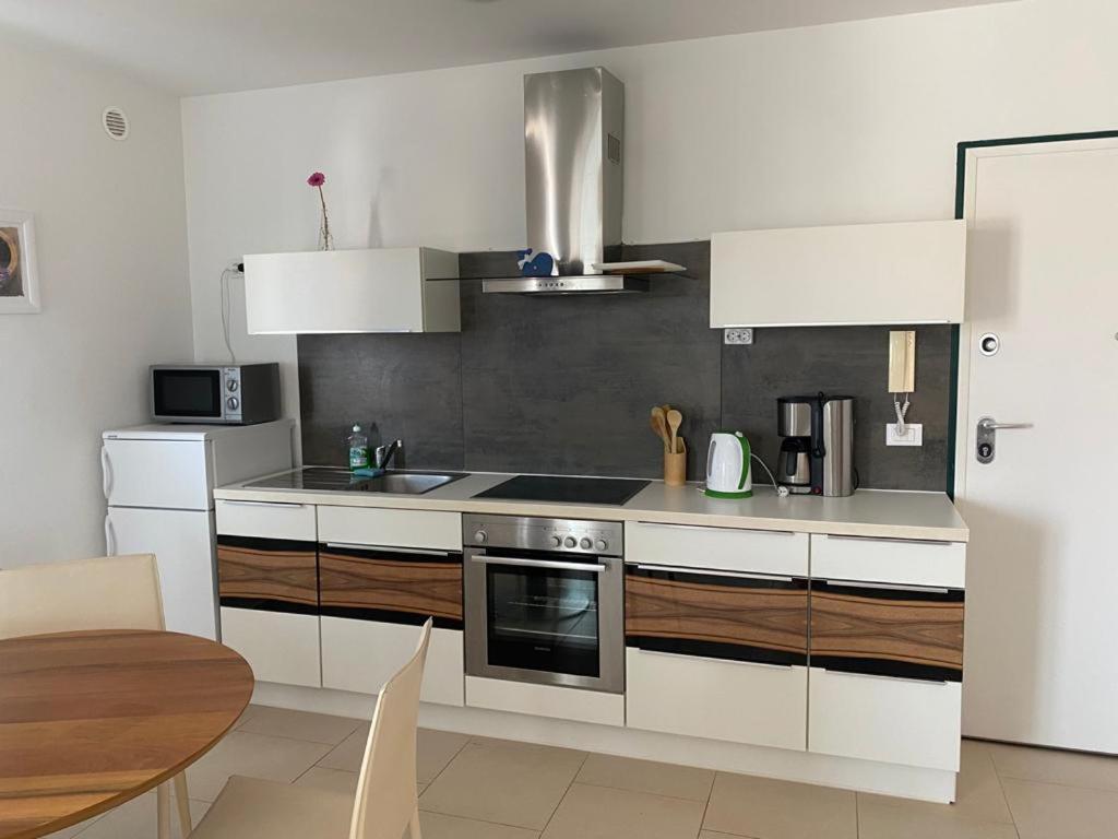 a kitchen with white cabinets and a stove top oven at Apartman M & M, Schöne Wohnung nur 200m vom Strand in Zaton