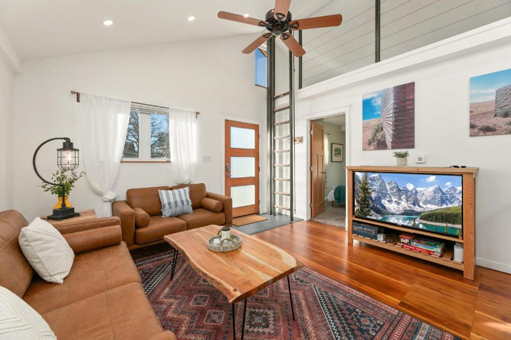 een woonkamer met een bank en een flatscreen-tv bij Vibrant Downtown Bungalow - Walk Everywhere! in Fort Collins
