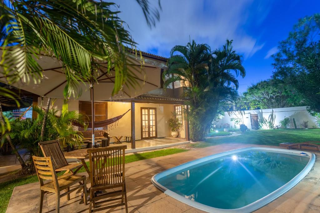 a villa with a swimming pool and a house at Sua casa na Praia in Salvador